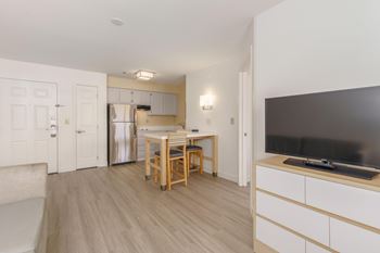 A kitchen with a table and chairs and a television
